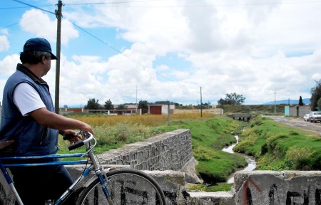 Un vecino mira la acequia, foco de contaminación, en la calle Oaxaca del municipio Rafael Lara Grajales.