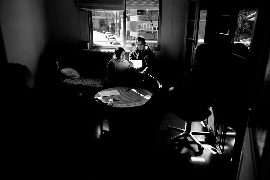 Mónica Ramos y su marido Javier Narváez, inmigrantes ecuatorianos, leen la orden de desahucio en el salón de su casa mientras esperan la llegada de la comisión judicial el 22 de febrero de 2012 en el barrio de Canillejas de Madrid. Foto: Olmo Calvo