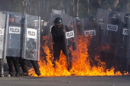 Policía en medio del fuego provocado por una bomba molotov. Foto Cuartoscuro. Toma de animalpolitico.com